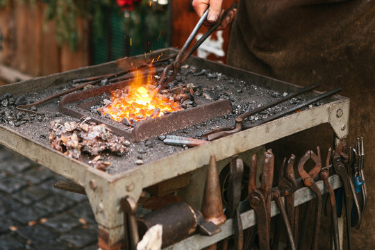 Blacksmith working metal with a hammer on the anvil in the forge