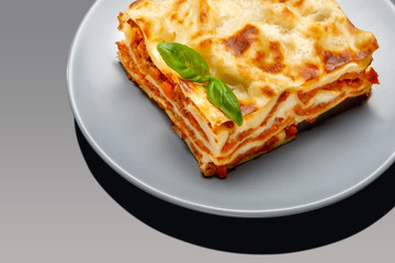 Portion of tasty lasagna on grey background