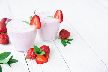 Smoothie with strawberry and berries on white wooden background. Flat lay. Top view. Fresh milkshake