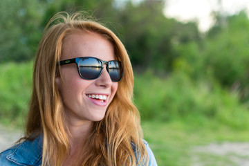 red haired girl / female with sunglasses looking at sunset