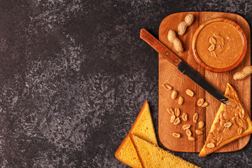 Bowl of peanut butter on wooden board.