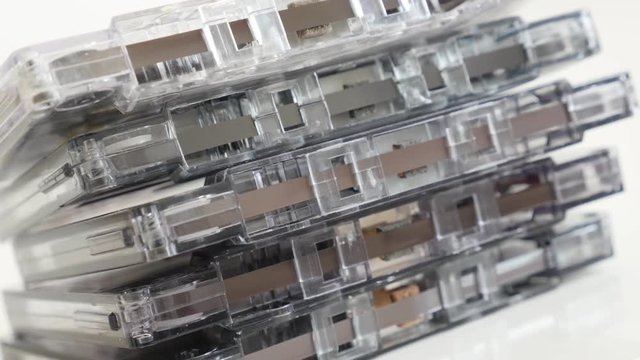 Slow pan analogue magnetic tapes close-up 4K 2160p 30fps UltraHD footage - Archived retro compact audio cassettes stacked 3840X2160 UHD panning video