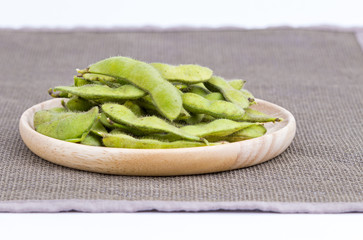 Green soybean (Vegetable soybean) boiled in wooden plate on black mate