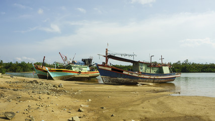 fishing boats stranded on the beach at noon.