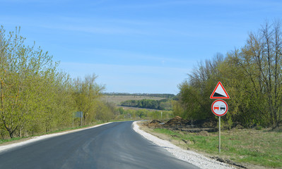 Загородная асфальтированная дорога со знаками "Крутой спуск" и "Обгон запрещён"
