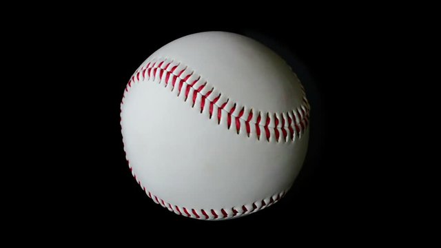 Isolated baseball is rotating slowly over black background. Seamless video.