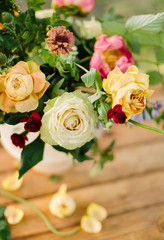 bouquet, holiday flower, gift and floral arrangement concept - top view of a delightful summer fresh white and yellow roses and pink peonies, decoration of festive bouquet on wooden table background