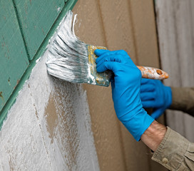 Close up of gloved hand priming the wall.