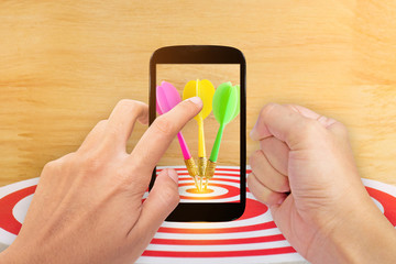 smartphone screen with arget dart with arrow over wooden background ,abstract background to target marketing concept .