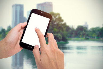 Man uses Mobile Phone outdoor in park.(vintage tone)