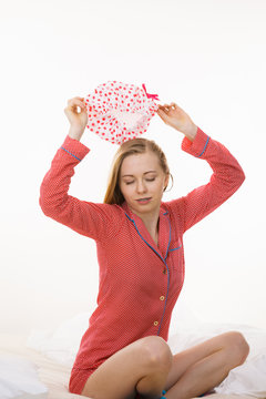 Young woman wearing pink pajamas putting bathing cap