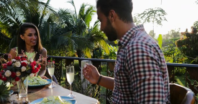 Attractive Couple Sitting At Table On Terrace Talking Drink Champagne, Young Man And Woman On Romantic Date In Outdoors Restaurant Slow Motion 60