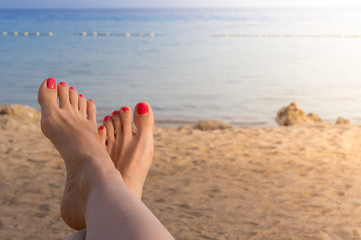 Vacation holidays. Woman feet closeup of girl relaxing on beach on sunbed enjoying sun on sunny summer day.