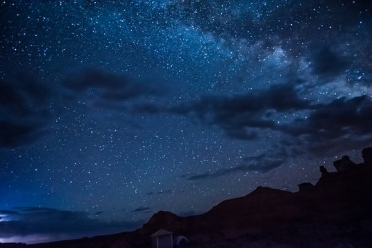 Night sky with milky way, clouds, canyons and campground