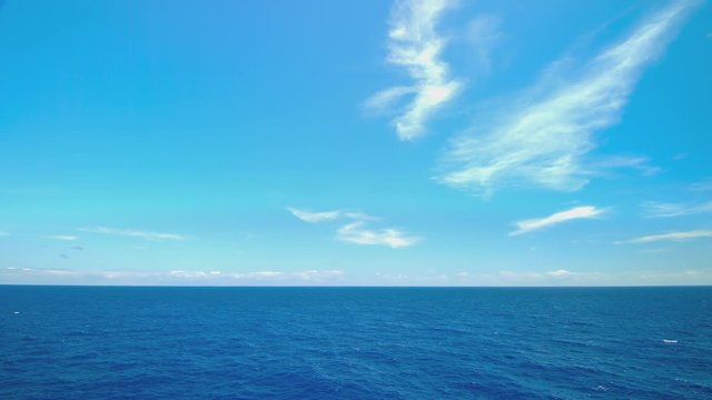 Moving Blue Oceanscape from Cruising Ship at Sea Sailing on Exotic Water with White Clouds on the Horizon during Idyllic Weather (Lower Third)
