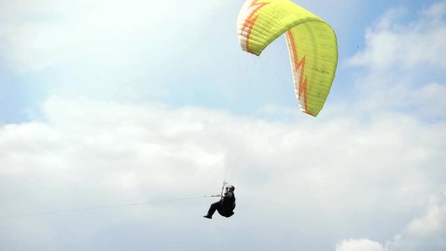 The paraglider takes off on the winch in the field. Extreme sports are gaining popularity. A man, boldly flies into the sky.