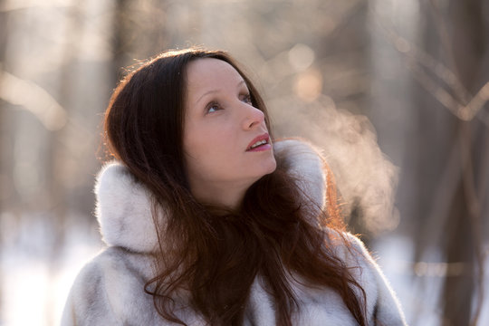 Cute Girl And Her Frosty Breath In The Winter Forest