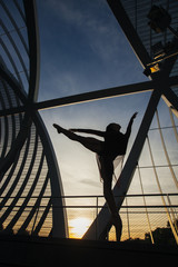 backlight shape of a woman dancing classical ballet on a bridge
