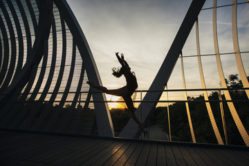 Fototapeta na wymiar shape of a woman jumping on a conceptual bridge