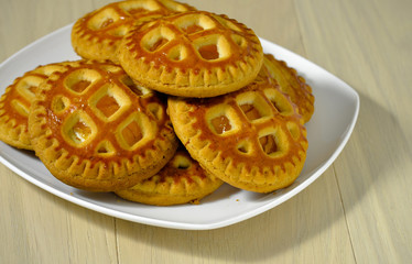 Fresh homemade cookies with dried apricots and cottage cheese on a white plate.
