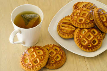 Morning tea with biscuits. On a light wooden table