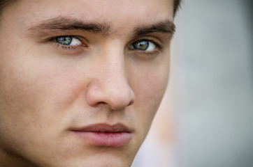 Handsome blond young man outdoors, looking away to a side