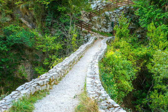 An old, arched stone bridge on the Canal del Texu trail between the village Bulnes and Poncebos, at the river Rio Cares in the Picos de Europa