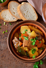 Stew with vegetables and potatoes on an old grunge background