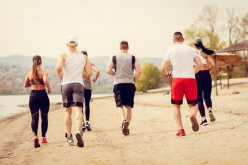 Group Friends Jogging On The Beach