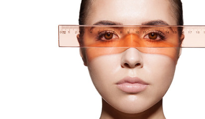 Close-up measures the proportions of a woman's face with rulers before a plastic operation. Isolated on white background