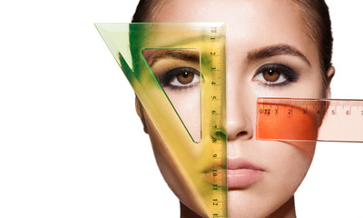 Measuring the proportions of a young woman's face with rulers before a plastic surgery. Isolated on...
