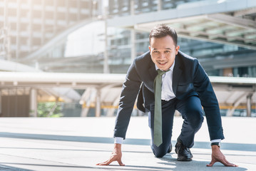 Happy confident Asian businessman ready to start his career or business with city in background. Business start concept. - obrazy, fototapety, plakaty