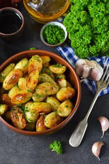 Young fried potatoes with garlic and dill on a black background
