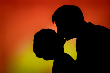 Cut paper silhouette of loving couple on a bright red yellow background