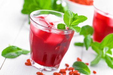 Healthy detox drink with goji berries infused in water with ice, cold refreshing beverage
