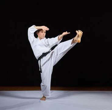 Sportsman trains karate blows against a black background Kaderov
