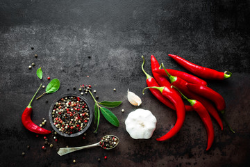 Red hot chili pepeprs and peppercorns on black metal background, top view - obrazy, fototapety, plakaty