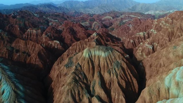 Flying a drone over the colorful Zhangye Rainbow Mountains; aerial view on sandstone hills and mountain chains covered by amazing pattern. Part 5 of a 5 part series-can be merged to 1 continuous movie