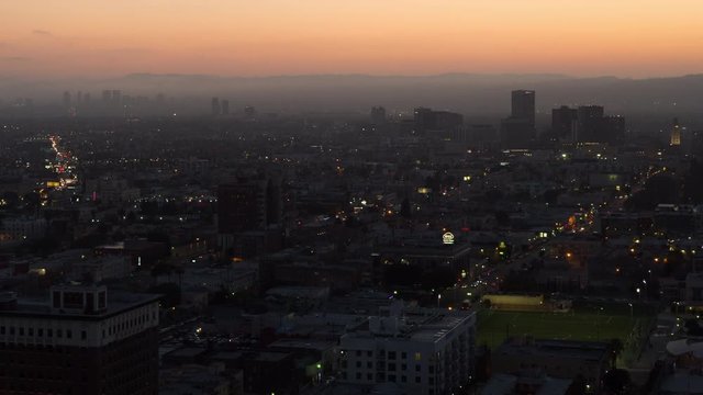 Time lapse dusk turning to night with street lights coming on, looking towards the mountains across the west side of Los Angeles and Hollywood. 4K