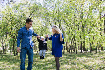 Happy young family spending time together outside in green nature