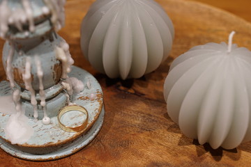 One gold ring beside a candlestick