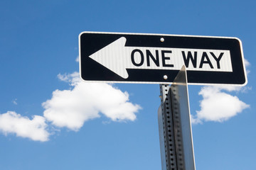 One way sign against blue sky