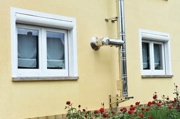 Außenkamin aus Edelstahl für Zentralheizung an einer Hauswand