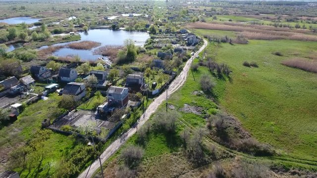 Impressive view on the country road along the Dnipro river with numerous summer cottages on its banks in Ukraine in a sunny day in spring. The skyscape and landscape look great and gorgeous