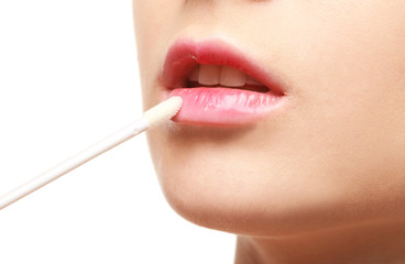 Obraz premium Beautiful young woman applying lipstick on white background, closeup