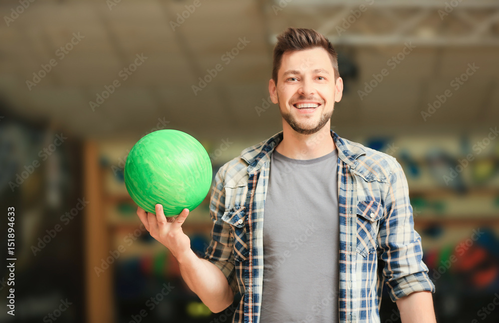 Sticker Handsome young man with ball in bowling club