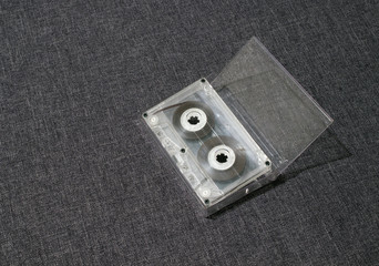 Old worn scratched audio tape on a gray background in a box