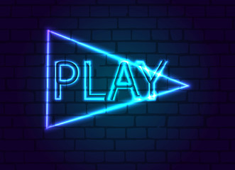 A neon sign in button to play against a brick wall.