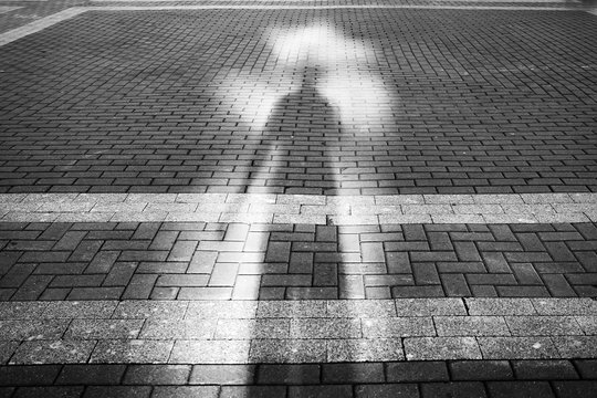 the shadow of a man on the pavement