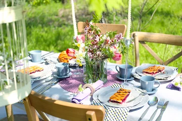 Zelfklevend Fotobehang Table setting with flowers in garden © Africa Studio
